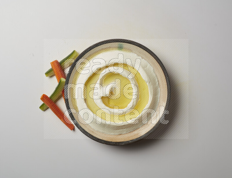 Lebnah garnished with olive oil in a pottery plate on a white background