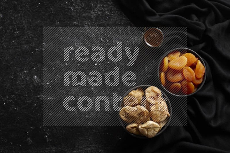 فواكه مجففة في أطباق فخارية مع القهوة علي خلفية سوداء خشبية