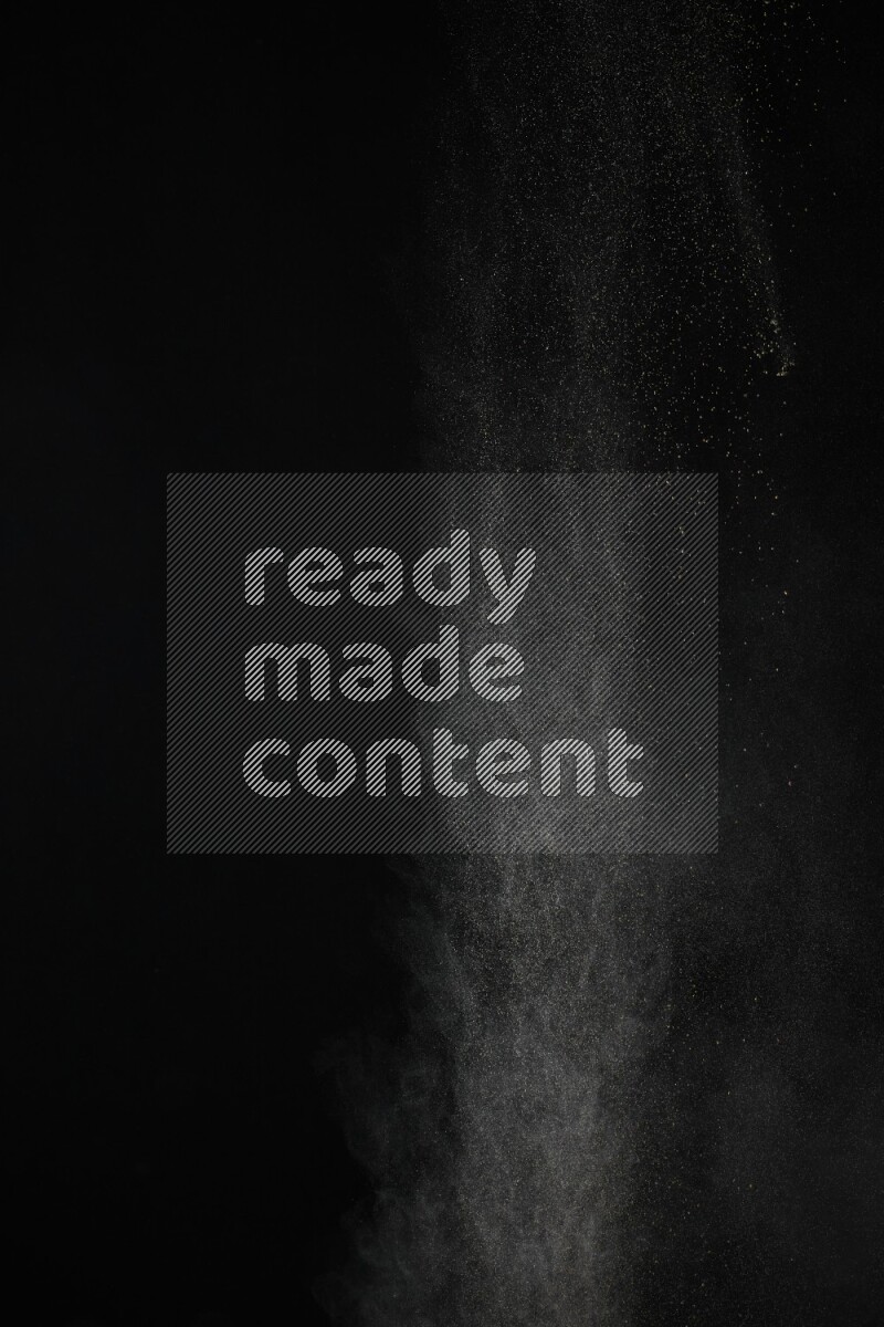 A side view of brown powder explosion on black background