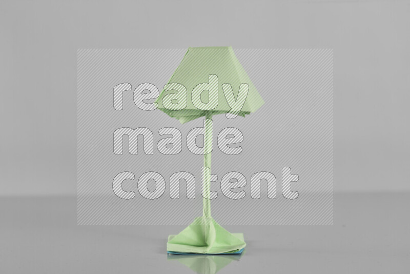 Origami floor lamp on grey background
