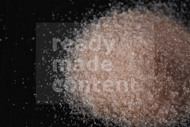 حفنة من ملح الهيمالايا الناعم على خلفية سوداء