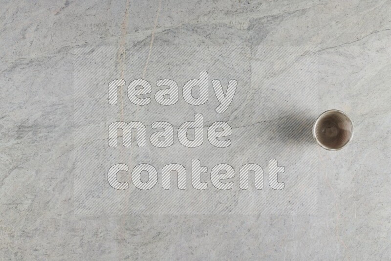 A multicolored pottery Cup on grey marble background