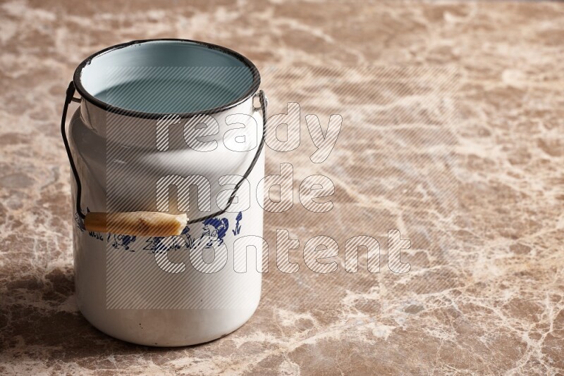 A vintage milk can on beige marble background