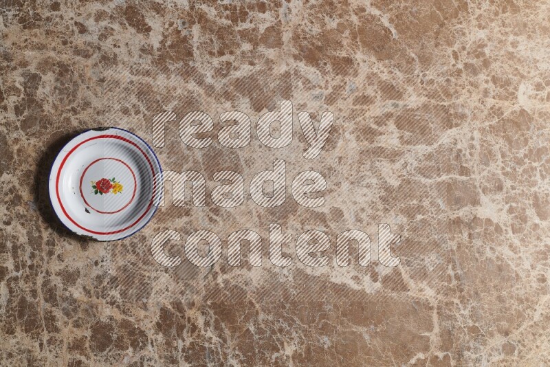 A vintage metal plate on beige marble background