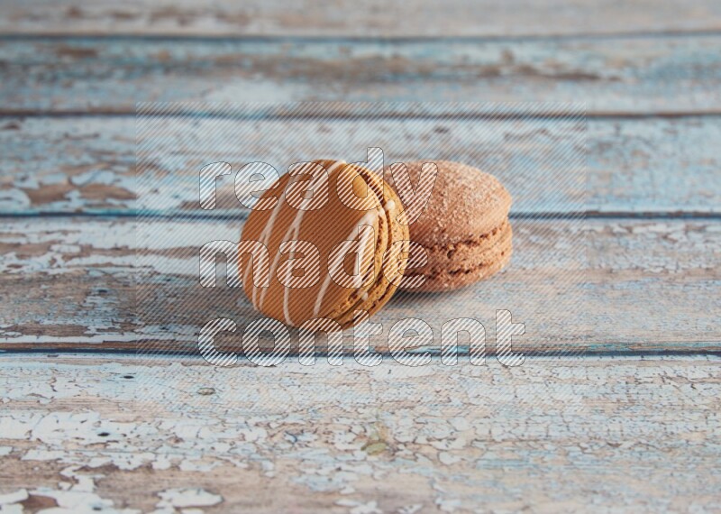 45º Shot of of two assorted Brown Irish Cream, and Brown Hazelnuts macarons  on light blue background