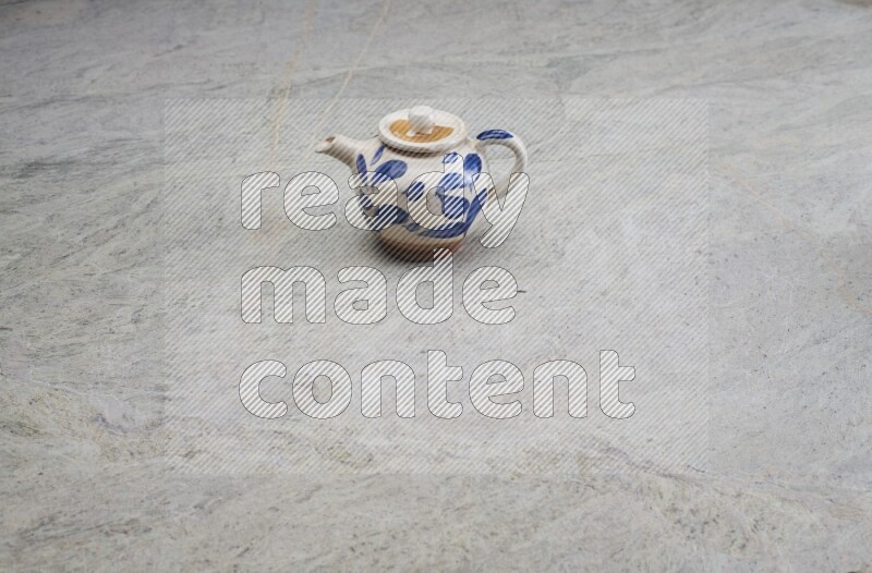 A pottery teapot on grey marble background