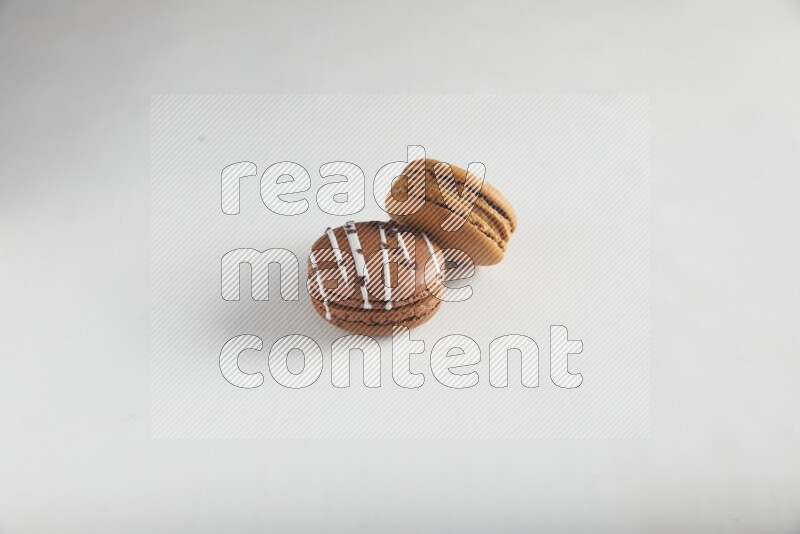 45º Shot of of two assorted Brown Irish Cream, and Brown white Chocolate Caramel macarons on white background
