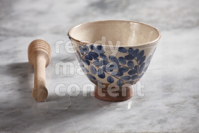 Decorative pottery bowl with wooden honey dipper on the side on grey marble background