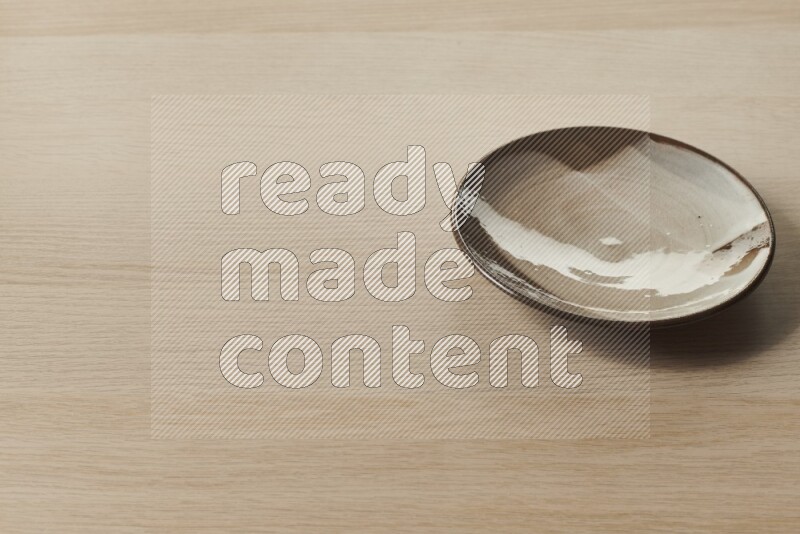 A multicolored pottery plate on light wooden background