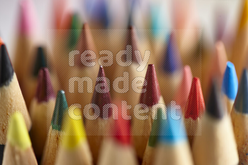 The image captures a close-up of sharpened colored pencils on multicolored background