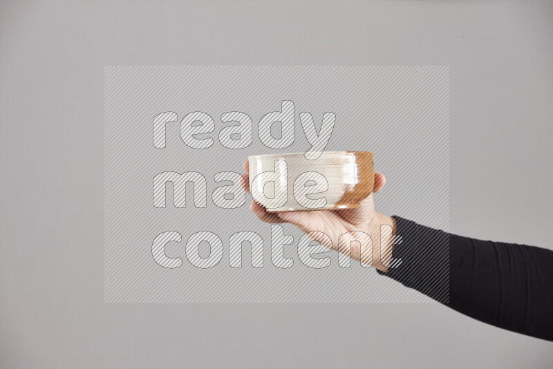 A woman in black abaya holding different pottery essentials in different positions