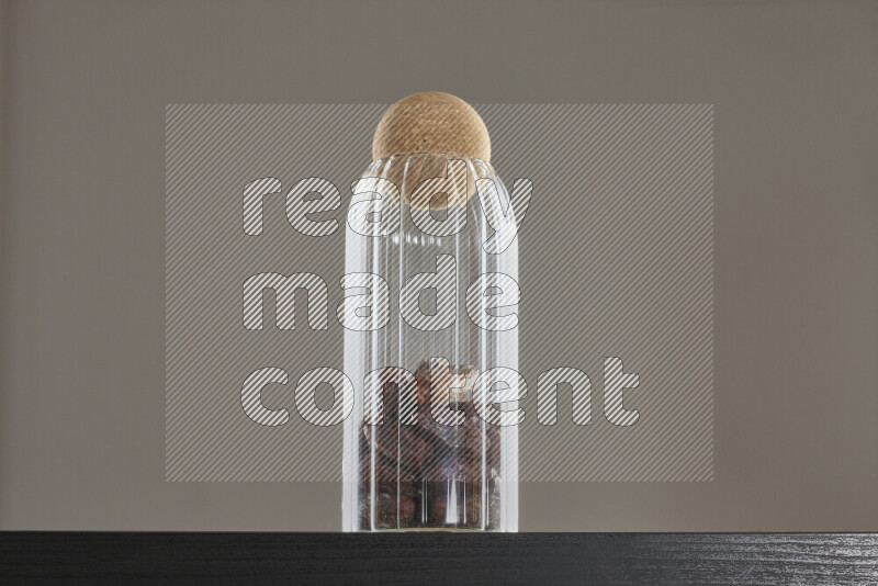 Dates in a glass jar on black background