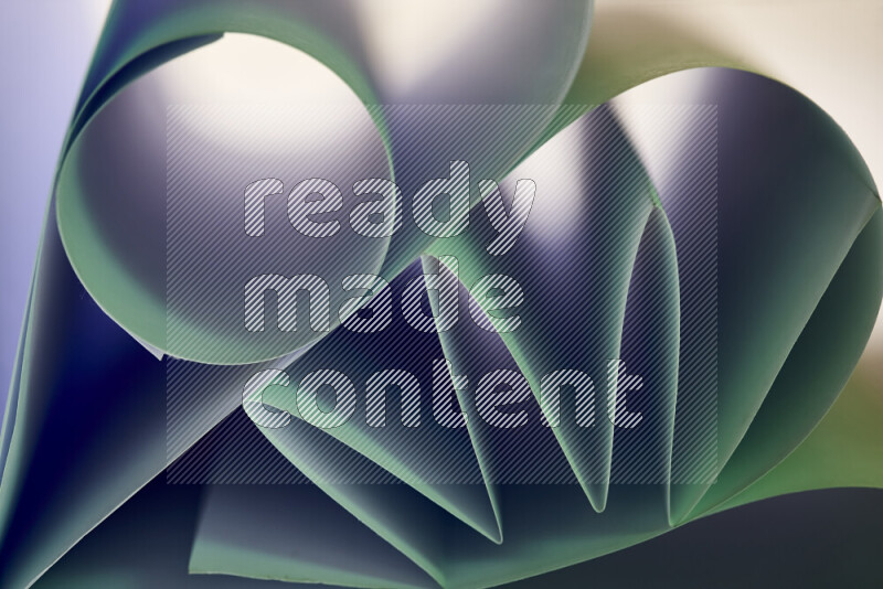 عرض فني لطيات الورق تخلق مزيج من الأشكال الهندسية، مضاءة بإضاءة ناعمة بدرجات اللون الأخضر