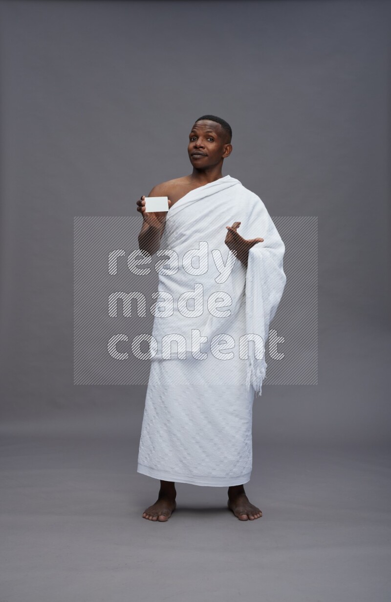 A man wearing Ehram Standing holding ATM card on gray background