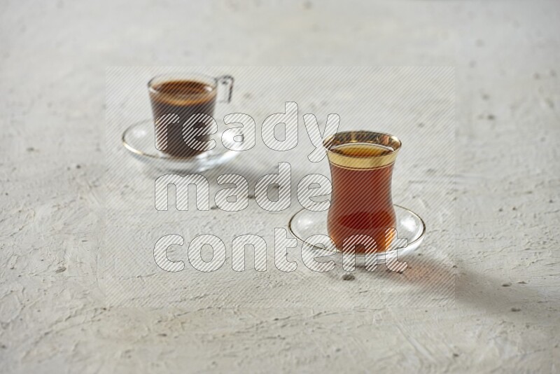 A tea glass cup with dates and coffee on textured white background