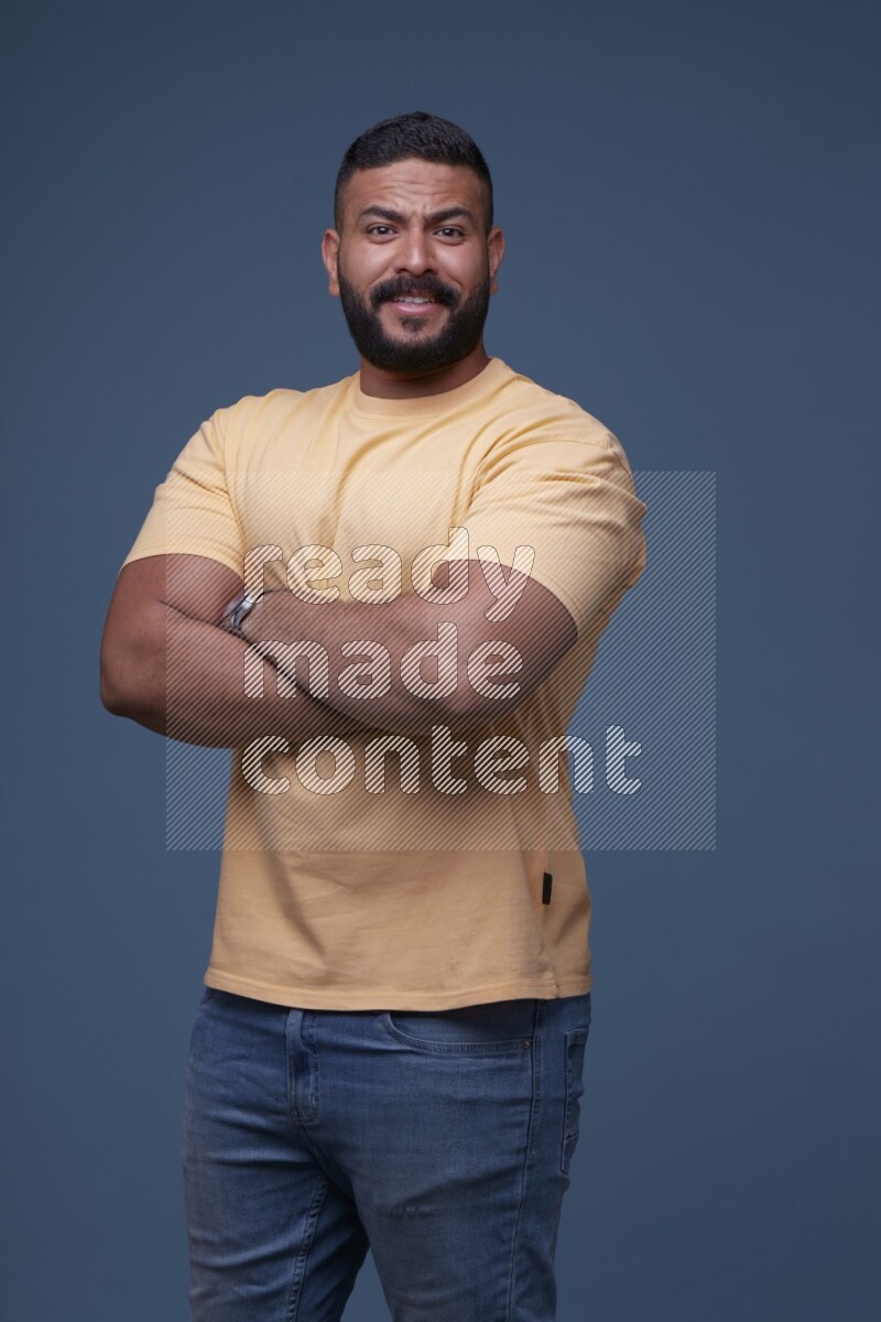 رجل يرتدي قميص اصفر بأكمام قصيرة وبنطال جينز ازرق يقف بأوضاع مختلفة