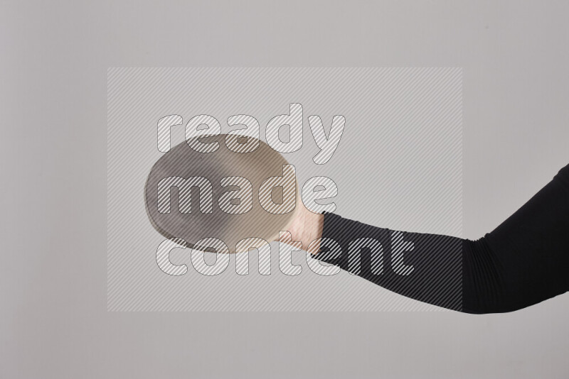 A woman in black abaya holding different pottery essentials in different positions