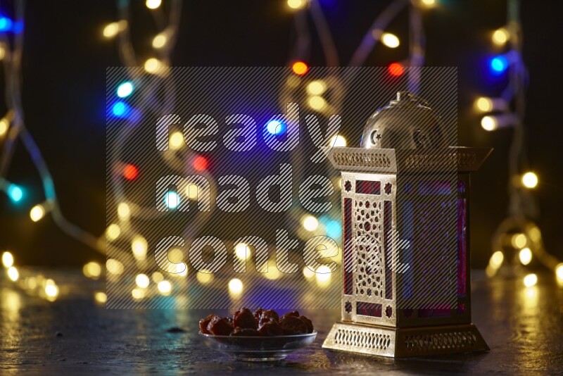 A traditional ramadan lantern surrounded by glowing fairy lights in a dark setup