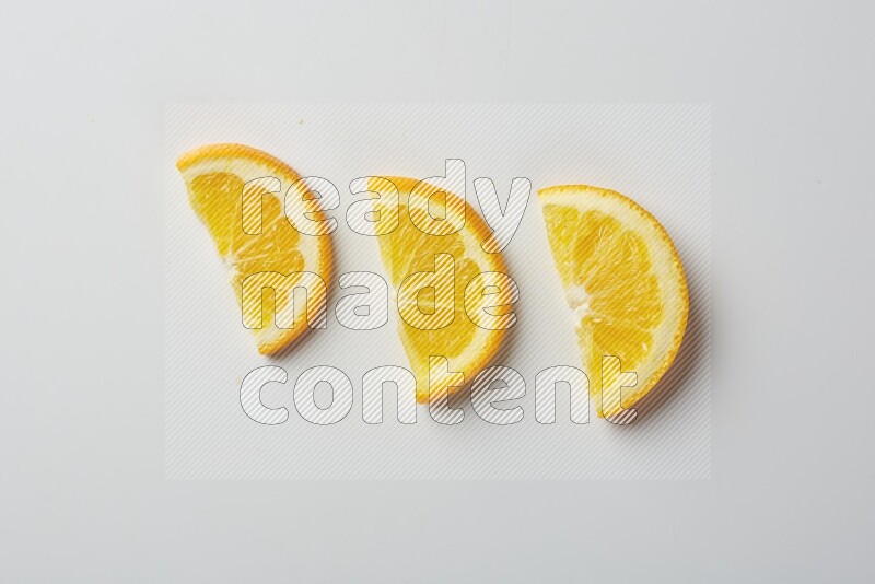 Three halves of an orange slices on white background
