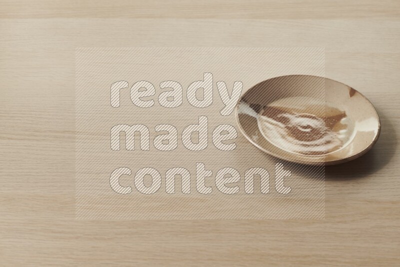 A multicolored pottery plate on light wooden background
