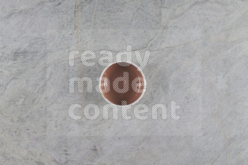 A brown pottery bowl on grey marble background