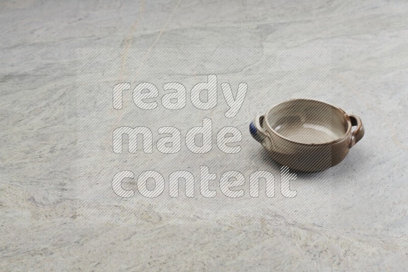 A multicolored pottery bowl on grey marble background