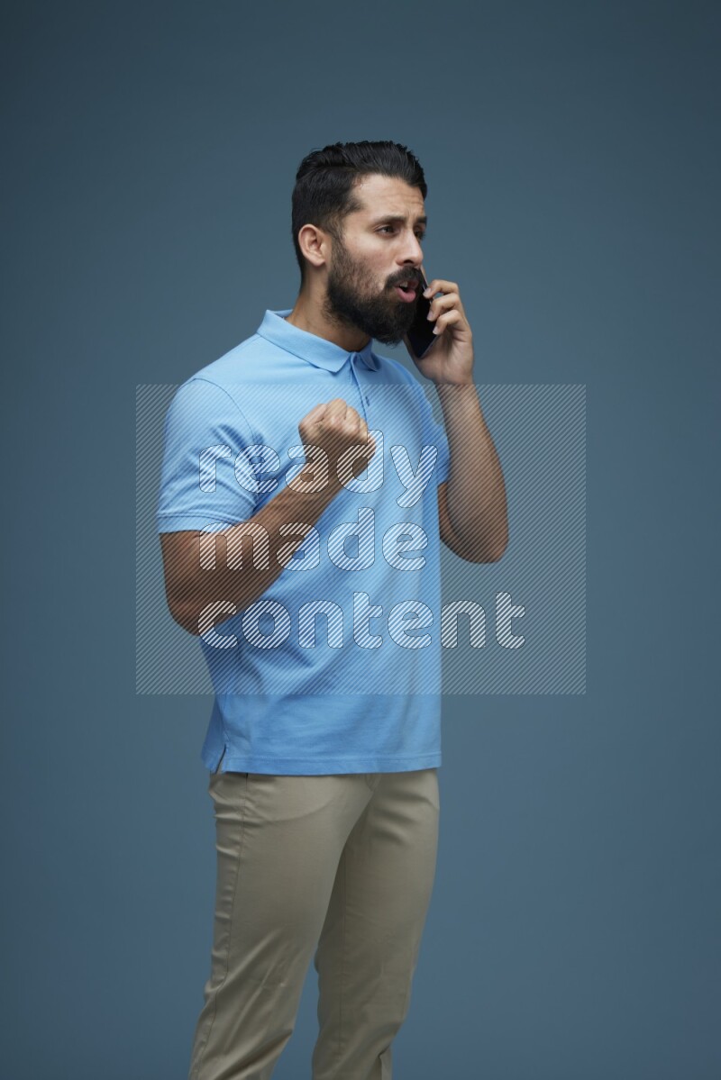 A man having a Call in a blue background wearing a Blue shirt