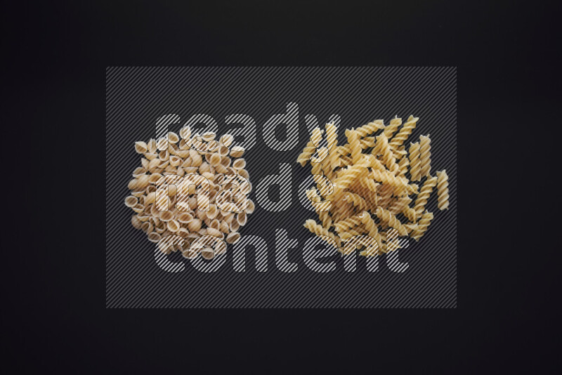 Different pasta types in bunches on black background