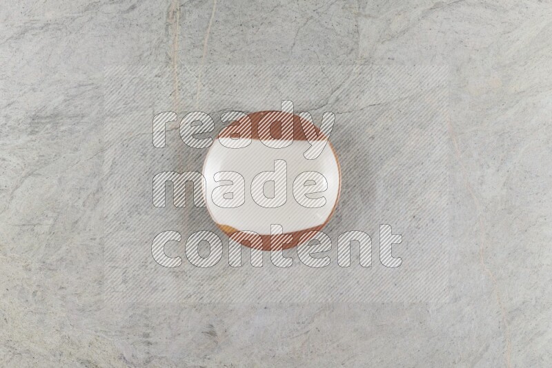 A multicolored pottery plate on grey marble background