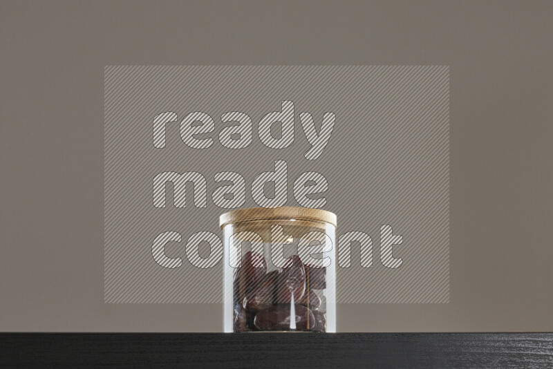 Dates in a glass jar on black background