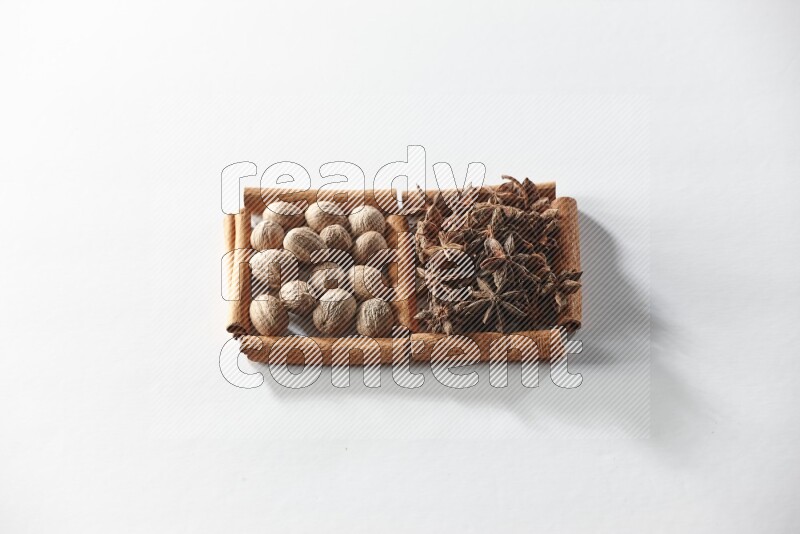 2 squares of cinnamon sticks full of star anise and nutmeg on white flooring