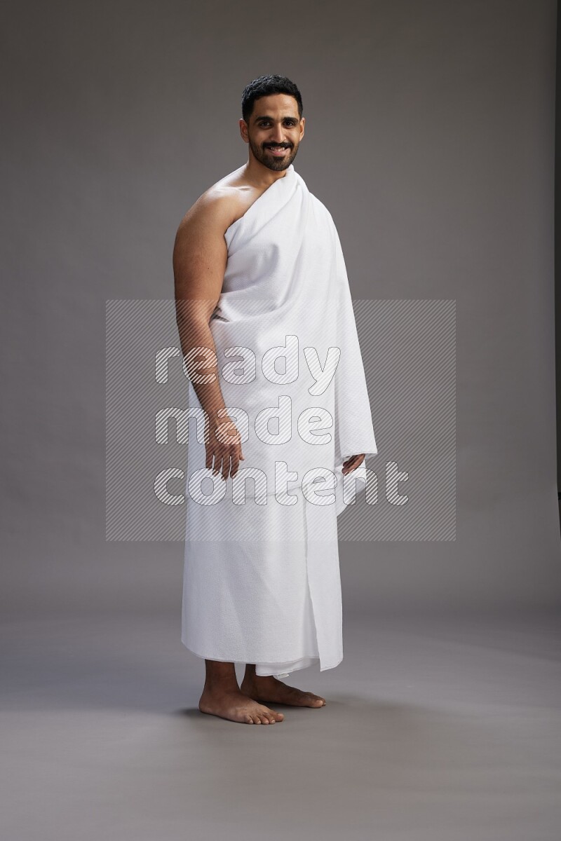 A man wearing Ehram Standing Interacting with the camera on gray background