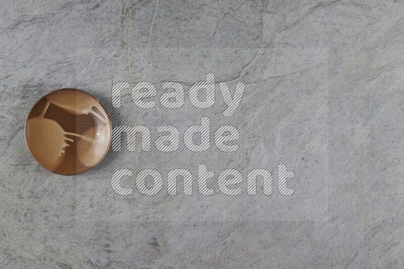 A multicolored pottery plate on grey marble background