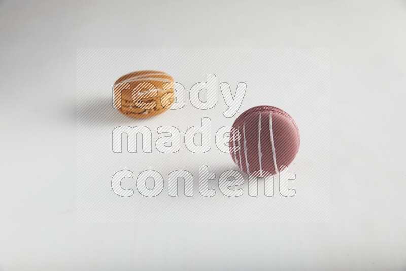 45º Shot of of two assorted Brown Irish Cream, and Red Poppy Flower macarons on white background