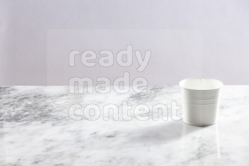 An empty white plant pot on grey marble background
