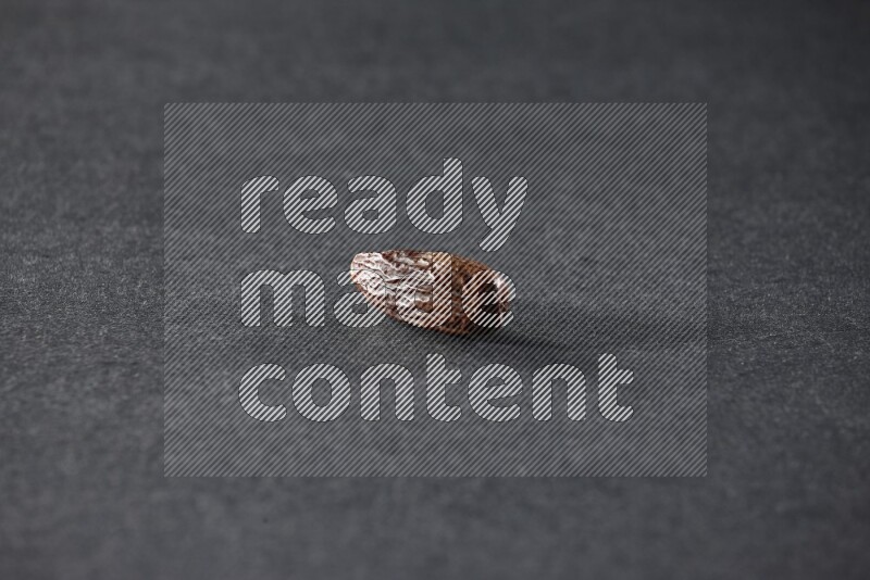 حبة واحدة من البلح المجفف علي خلفية سوداء