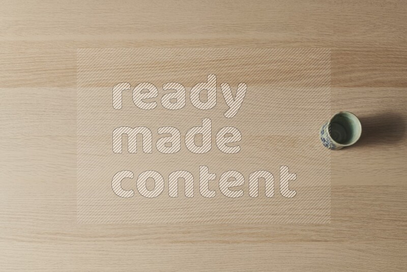 A pottery cup on light wooden background