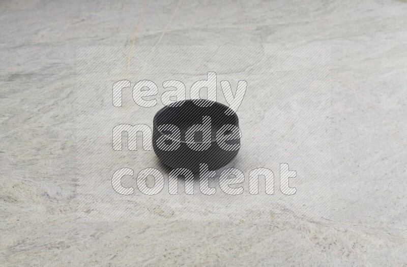 A black pottery bowl on grey marble background