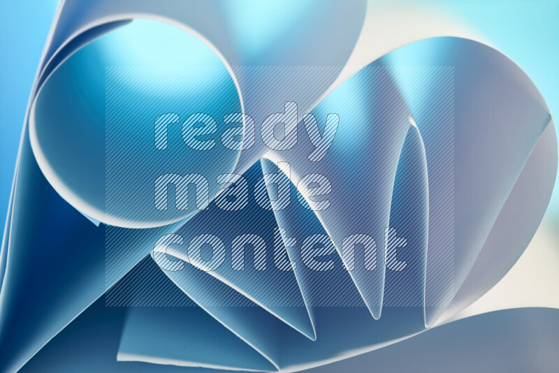An artistic display of paper folds creating a harmonious blend of geometric shapes, highlighted by soft lighting in blue and white tones
