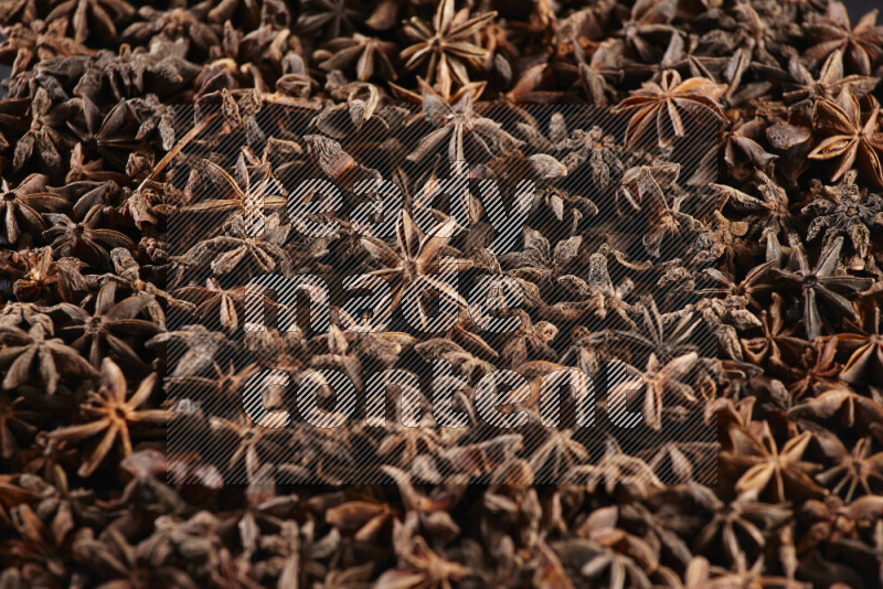 Star Anise fill the frame on black flooring