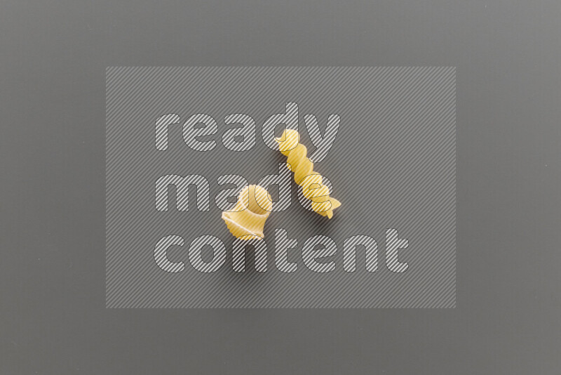 Pipe pasta with other types of pasta on grey background
