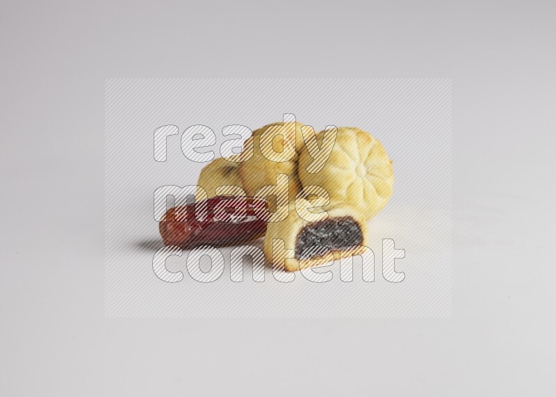 Four Pieces of Maamoul filled with date one of them is cut direct on white background
