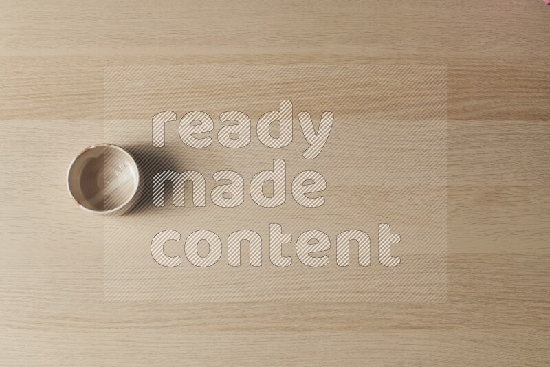 A multicolored pottery bowl on light wooden background