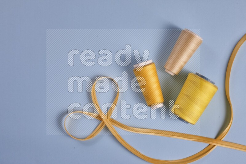 A yellow collection of sewing and tailoring tools arranged on a blue background