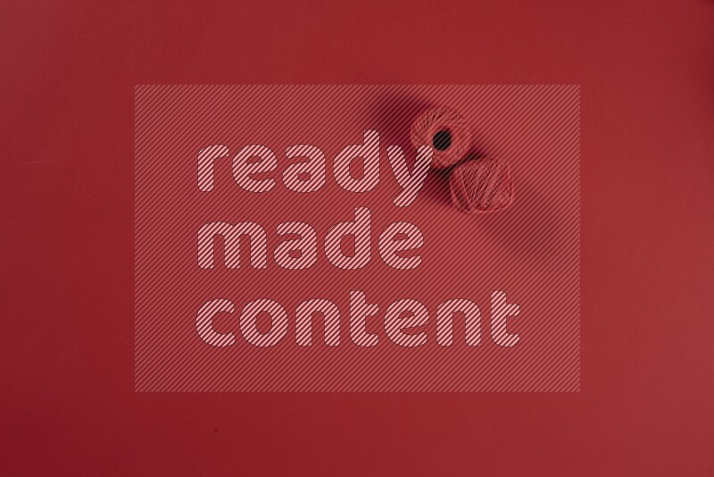 A red collection of sewing and tailoring tools arranged on a red background