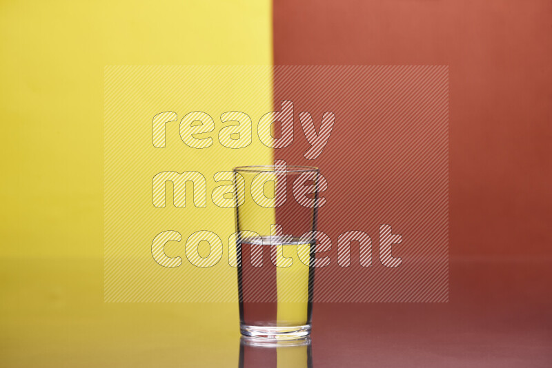 The image features a clear glassware filled with water, set against yellow and dark orange background