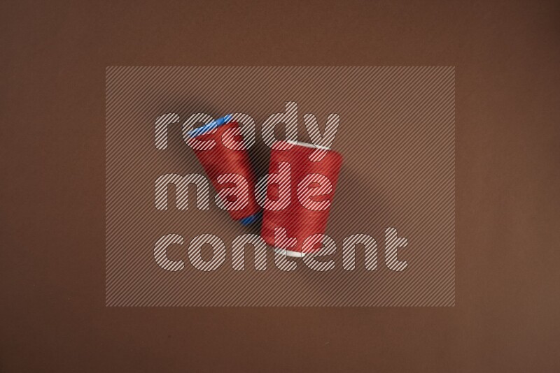 A red collection of sewing and tailoring tools arranged on a brown background