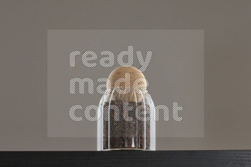 Dried basil in a glass jar on black background