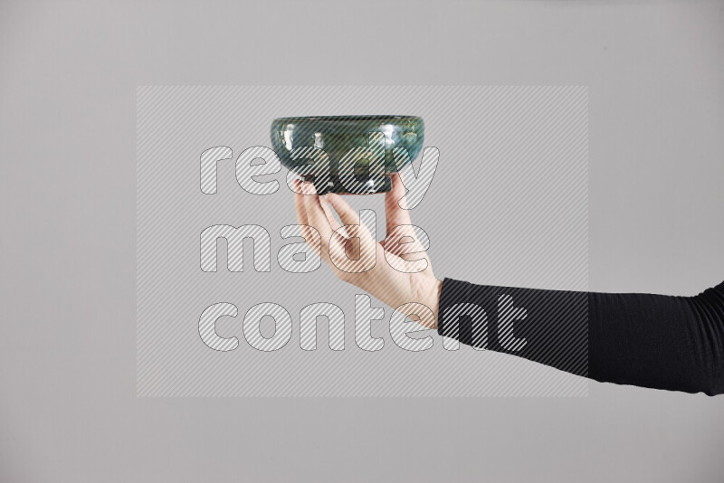 A woman in black abaya holding different pottery essentials in different positions