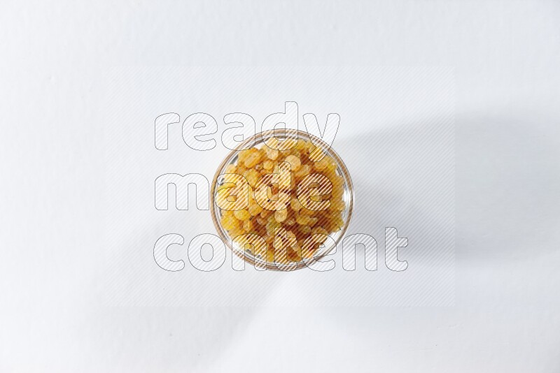 A glass bowl full of raisins on a white background in different angles
